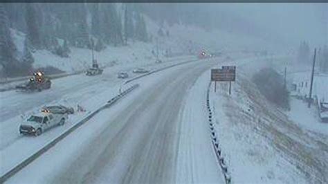 Traffic camera images show snow covering parts of the road, . . Eisenhower tunnel cam
